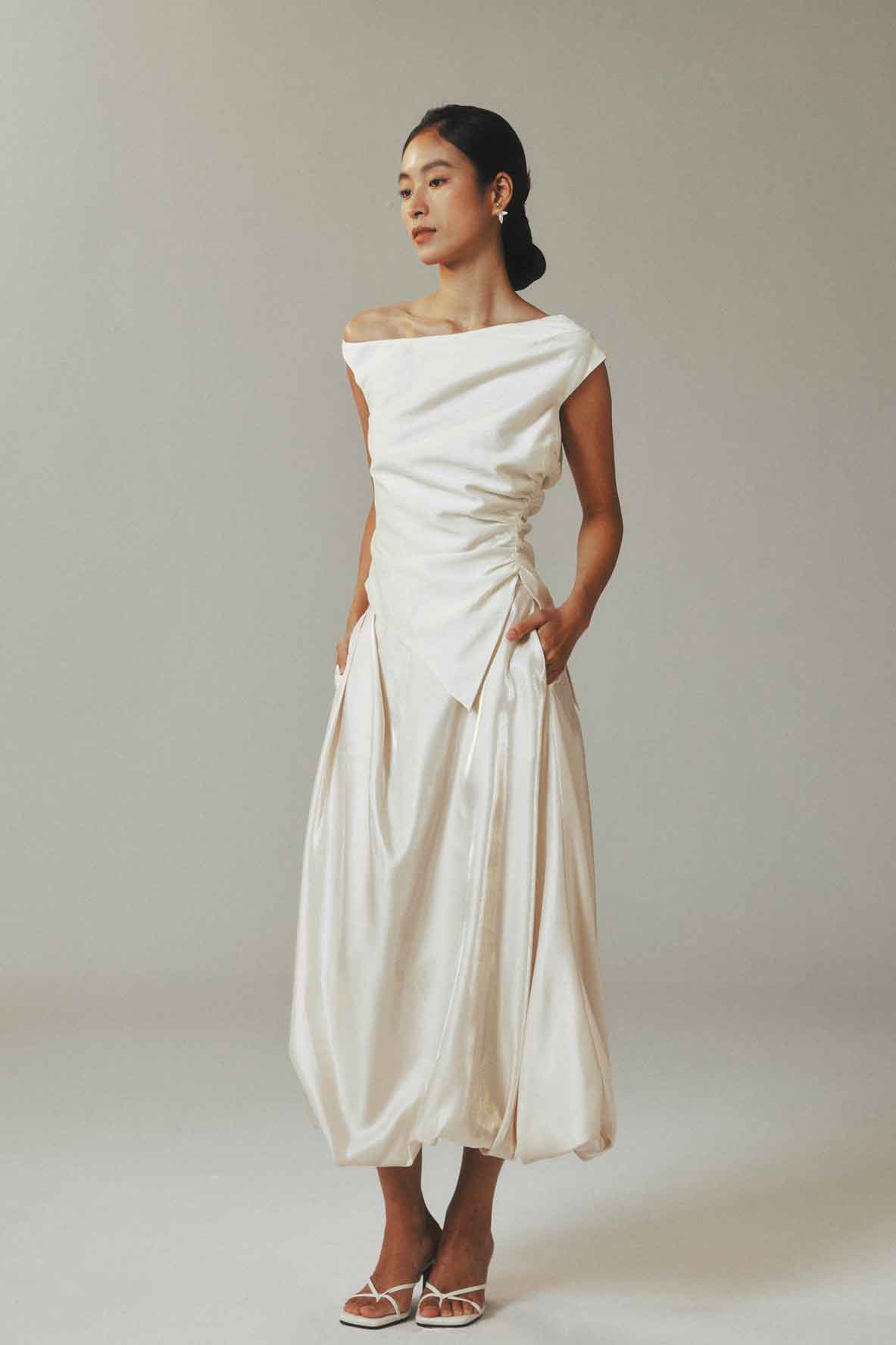 Model in slouchy one-shoulder linen top
with flowy midi skirt