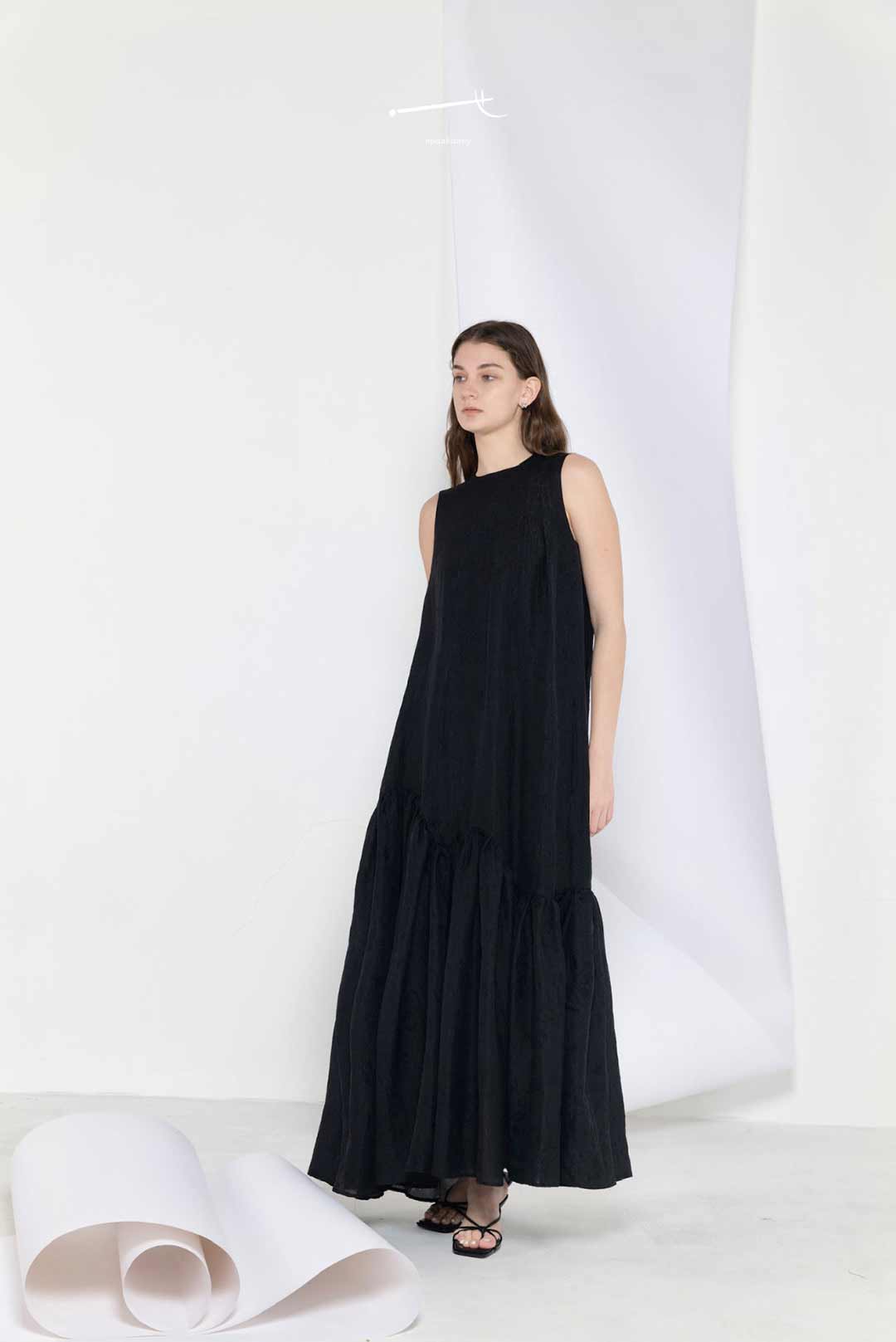 Model wearing black loose-fitting maxi
dress with wide hem