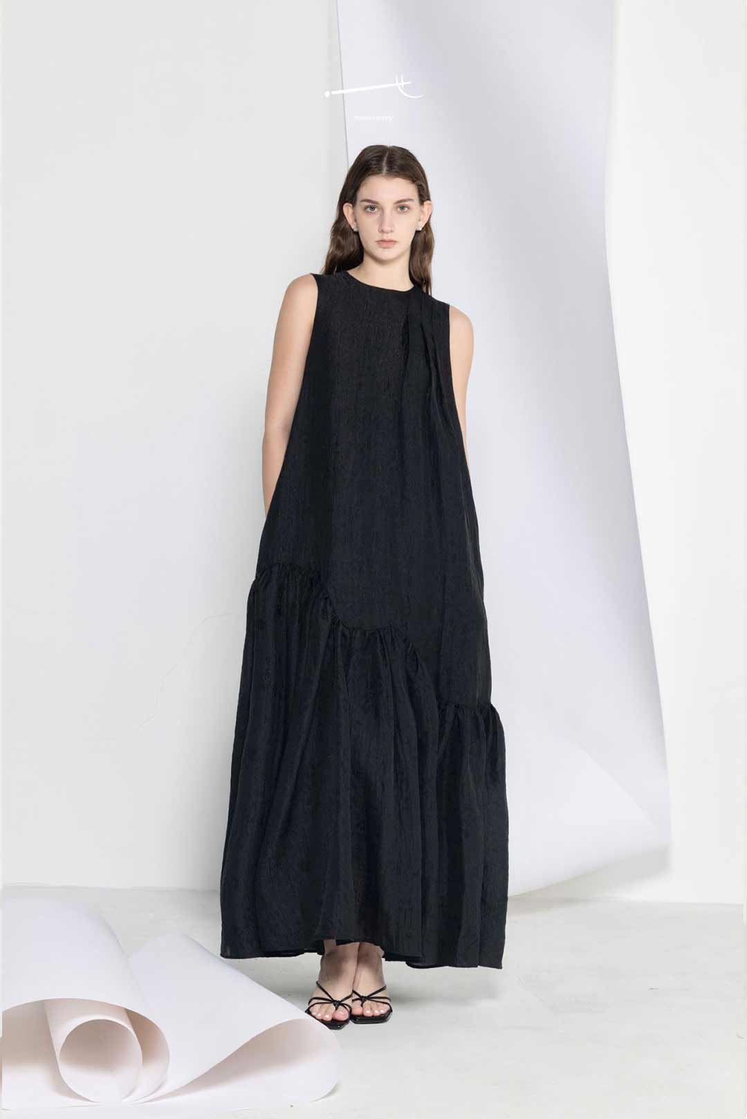 Model wearing black loose-fitting maxi
dress with wide hem