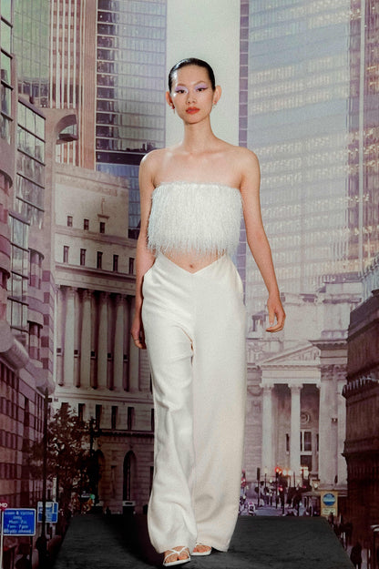 Model in snowflake fringe bustier and
wide-leg patchwork trousers
