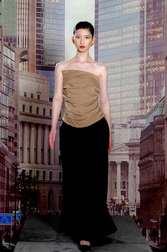 Woman in a beige top and black skirt standing in front of a cityscape