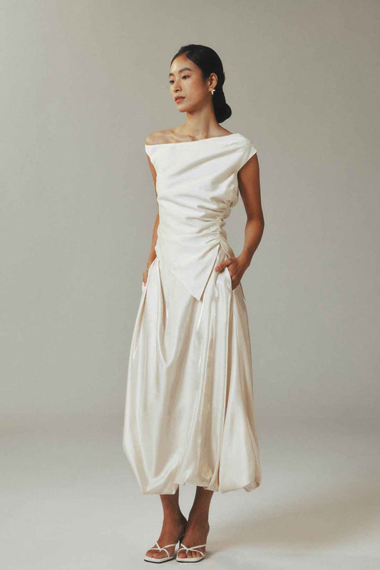 Model in slouchy one-shoulder linen top
with flowy midi skirt