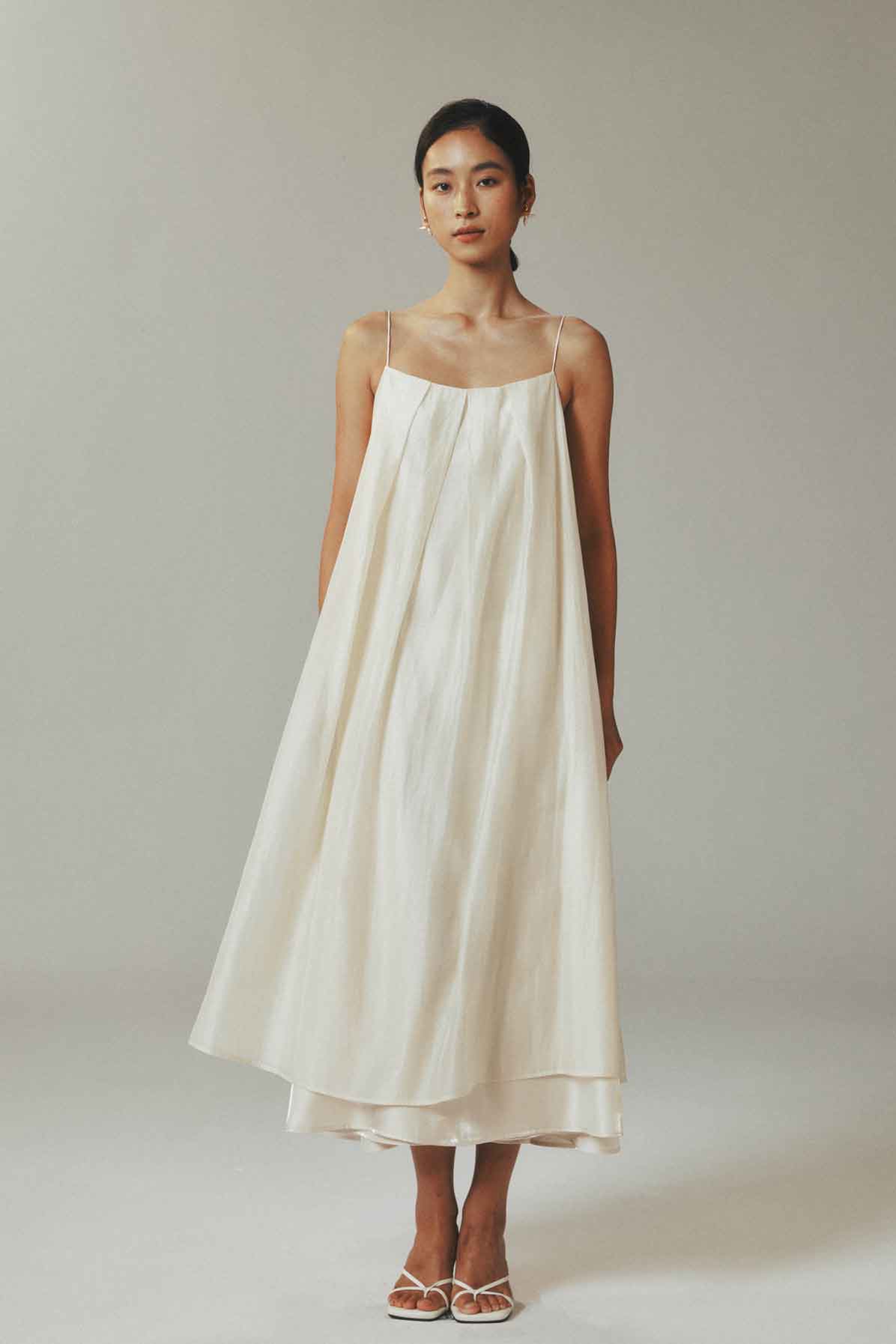Woman wearing a white dress against a plain background