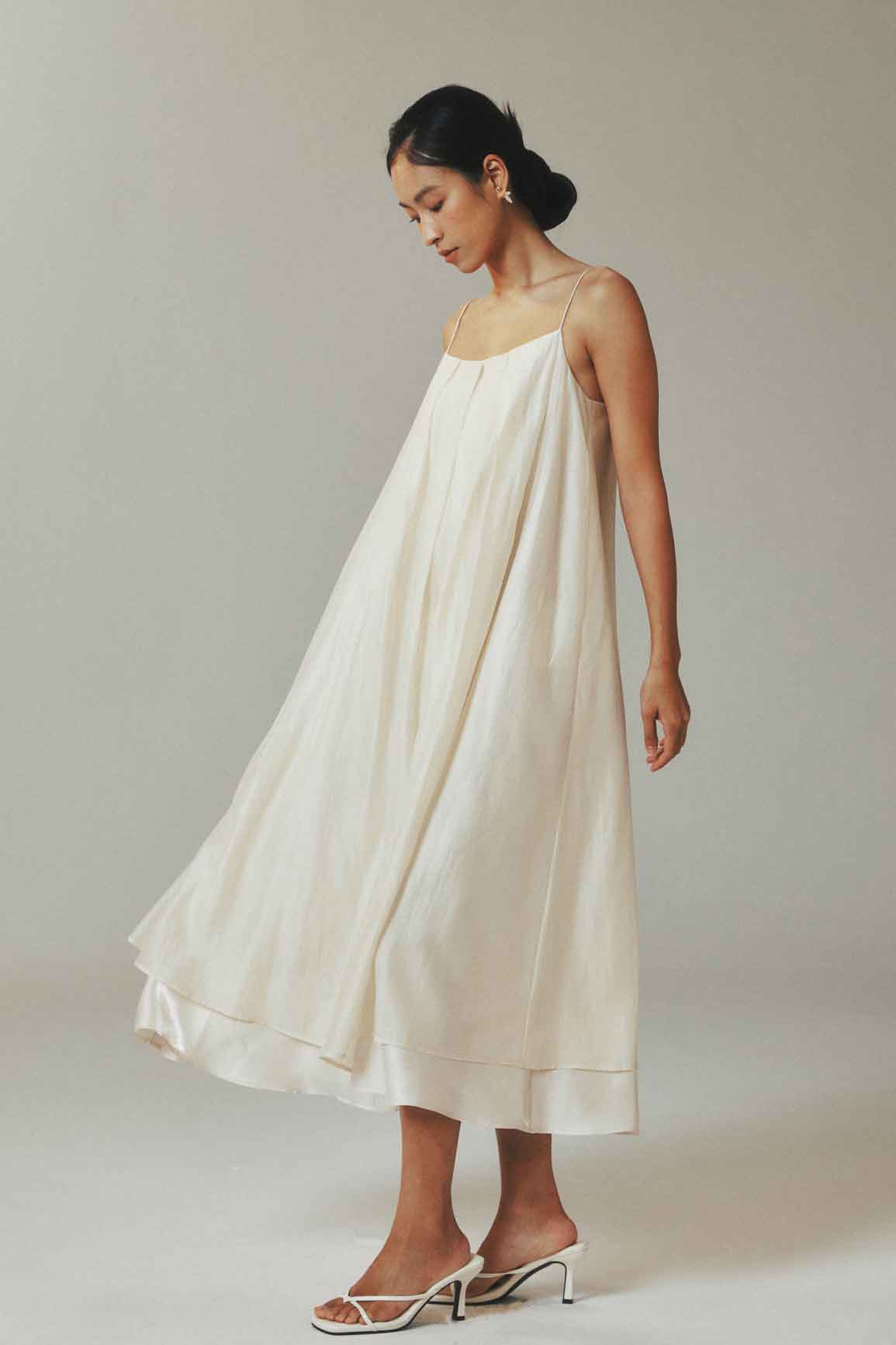 Woman wearing a white dress against a plain background