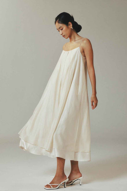 Woman wearing a white dress against a plain background
