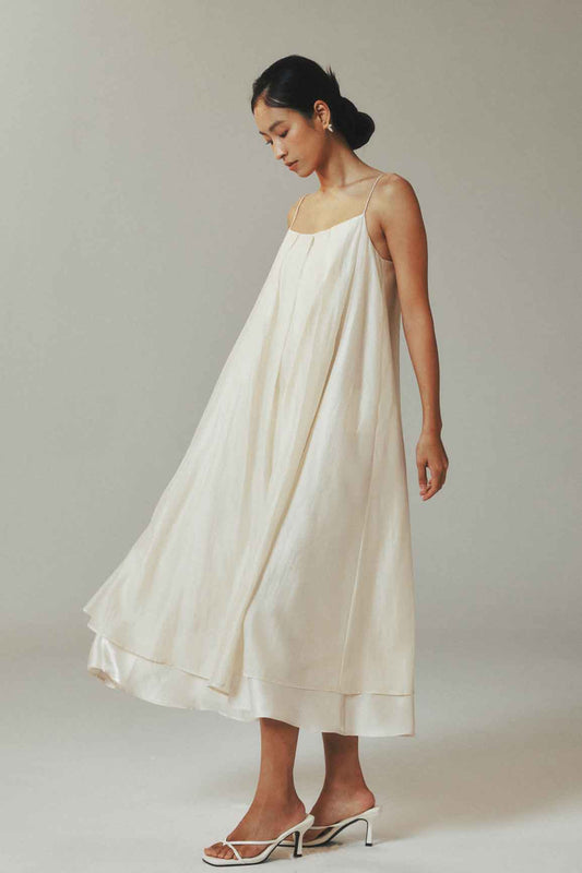 Woman wearing a white dress against a plain background