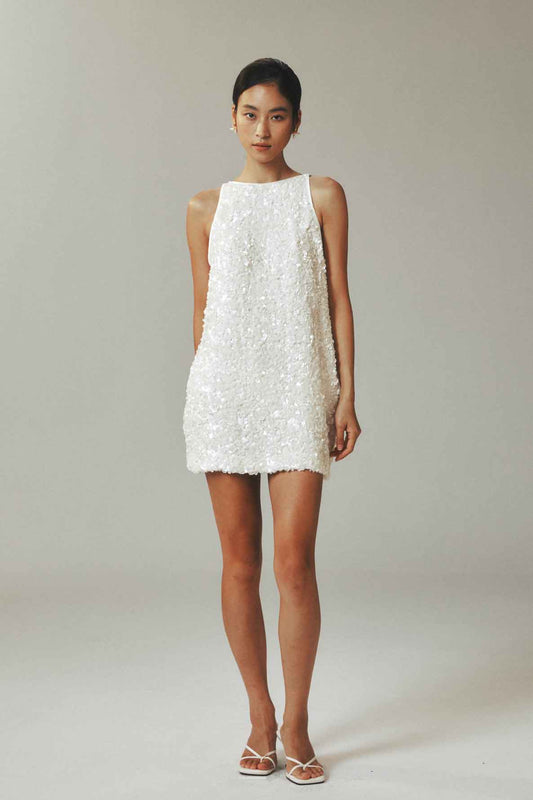 Model wearing sleeveless straight tank dress with star sequins