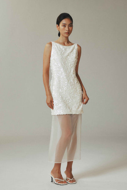 Model wearing white sequin mini dress with sheer tulle overlay