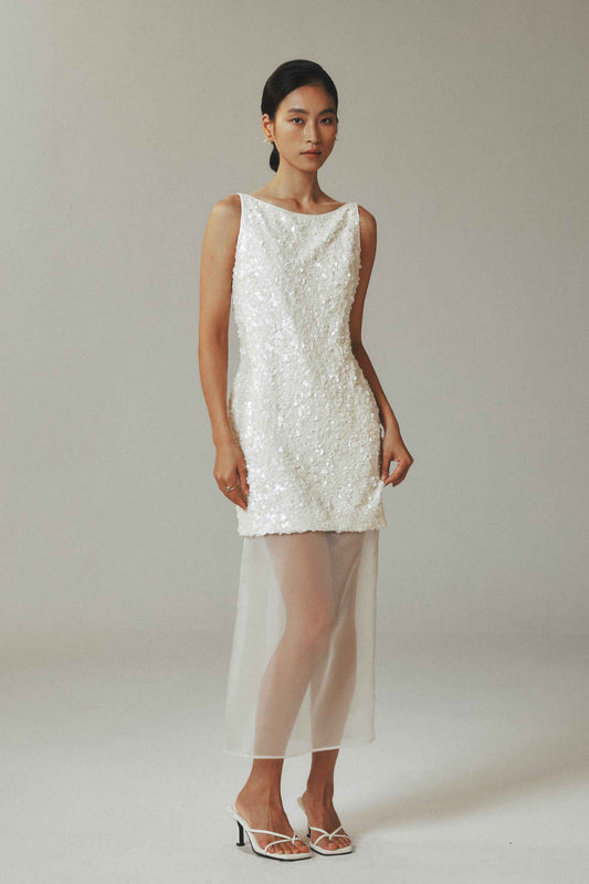 Model wearing white sequin mini dress with sheer tulle overlay