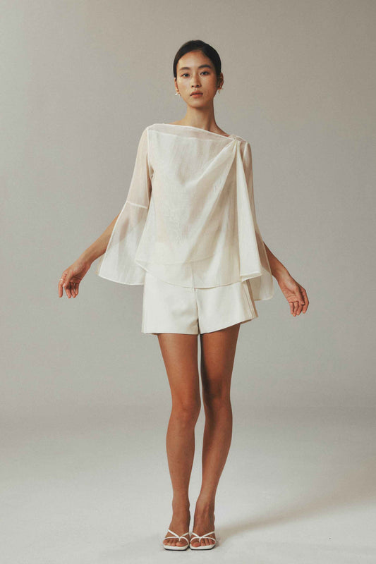 Model wearing lightweight two-piece set with long sleeve top and side pleated shorts
