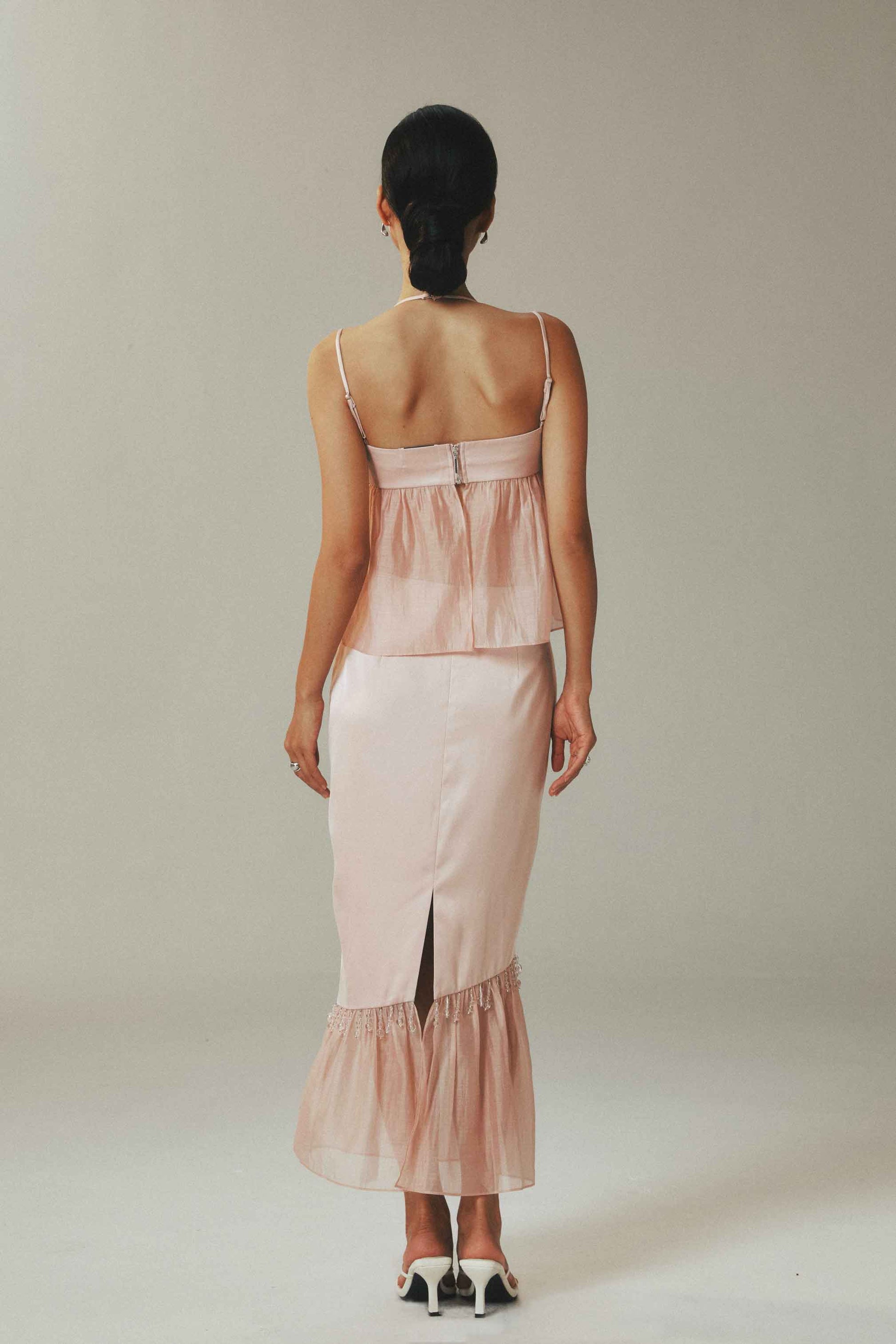 Woman wearing a light pink dress with a plain background