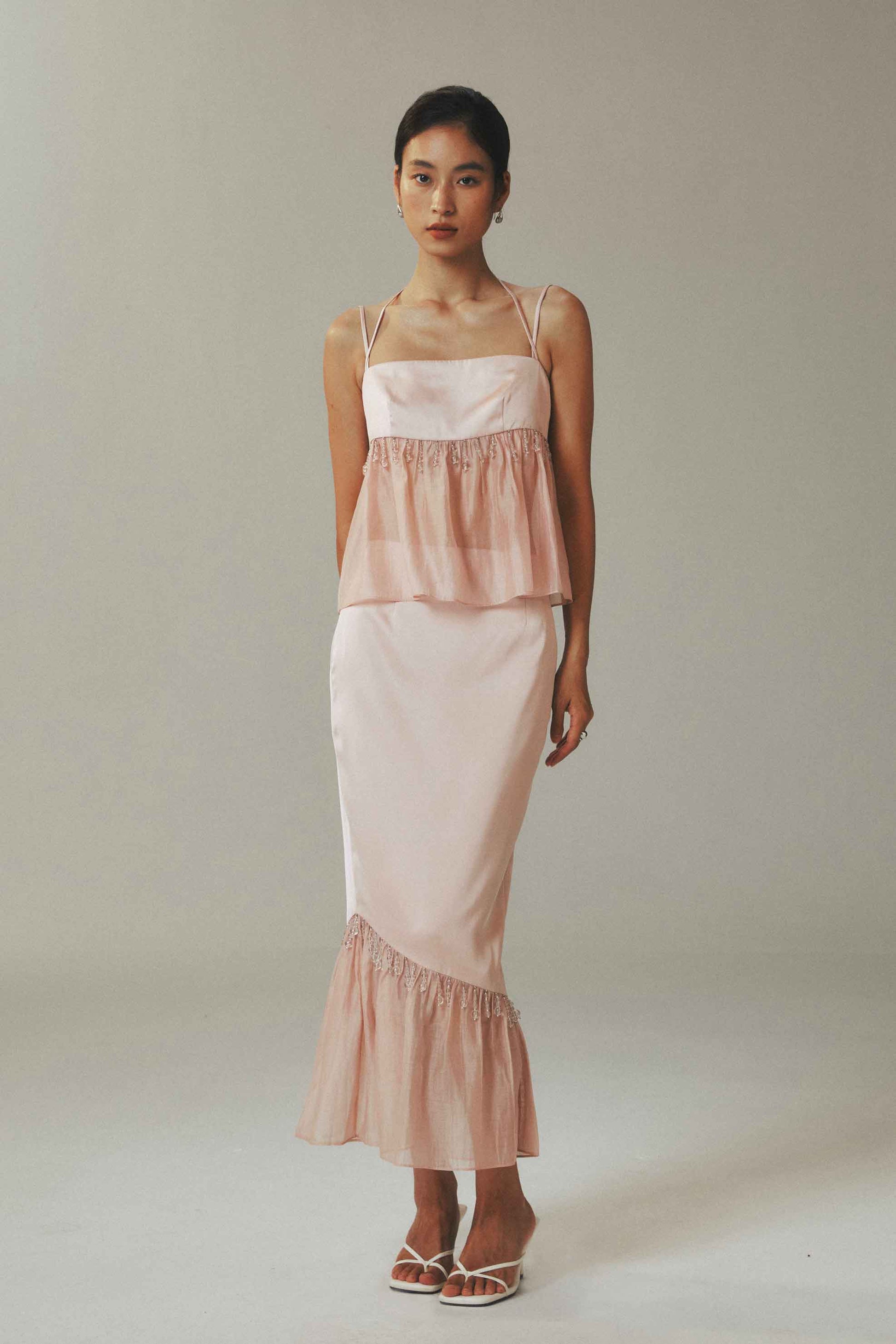 Model wearing halter crop top and skirt with
crystal bead detailing in ice-silk fabric