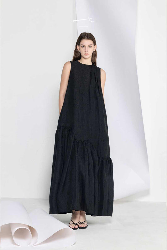 Model wearing black loose-fitting maxi
dress with wide hem
